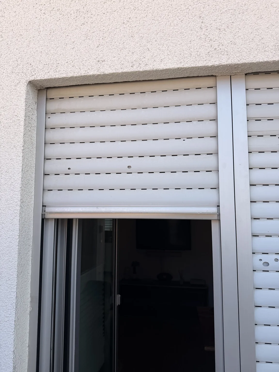 Beschädigter Rollladen an einem Fenster