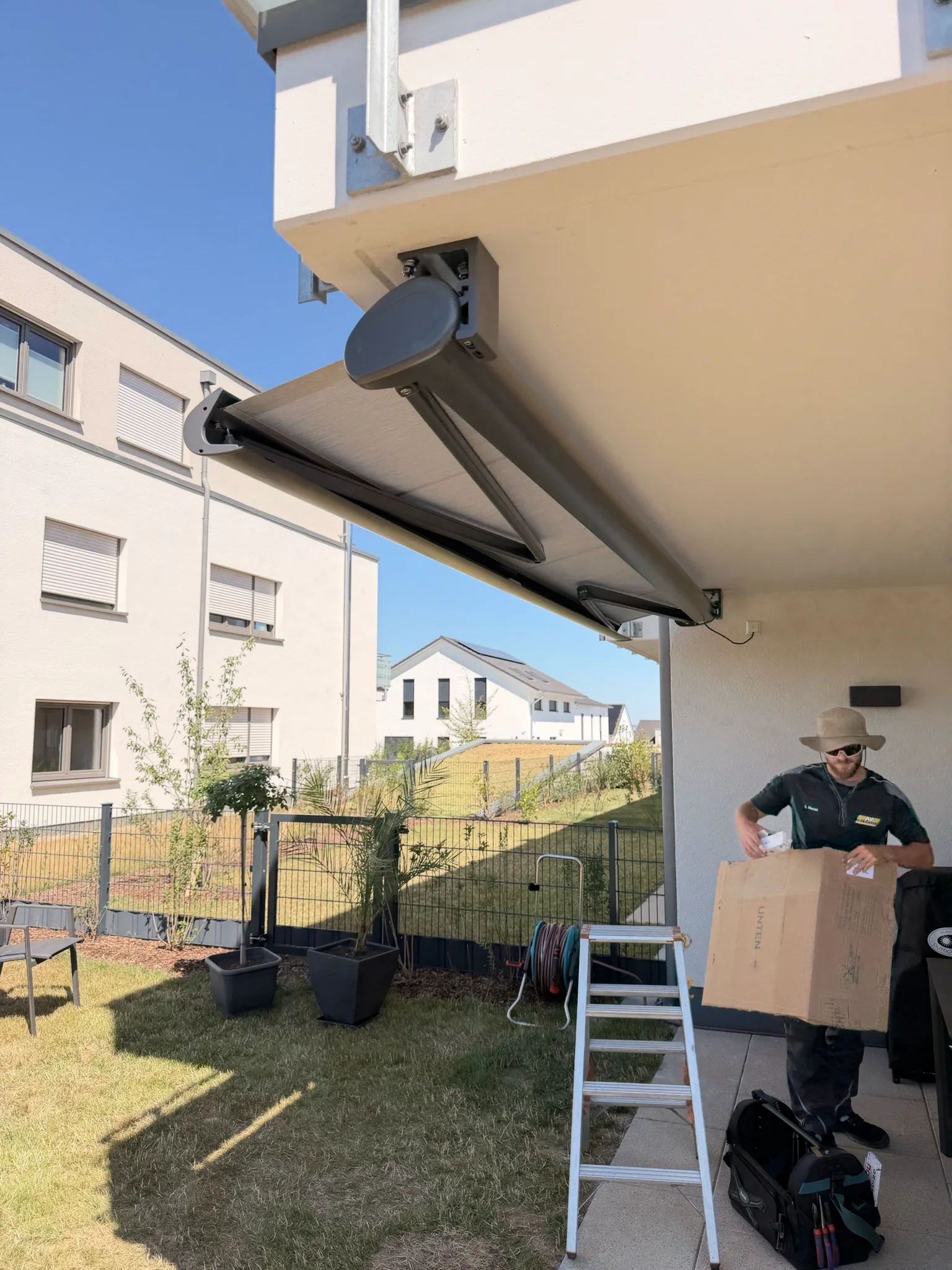 AY-Techniker bei der Markisenmontage auf einer Terrasse