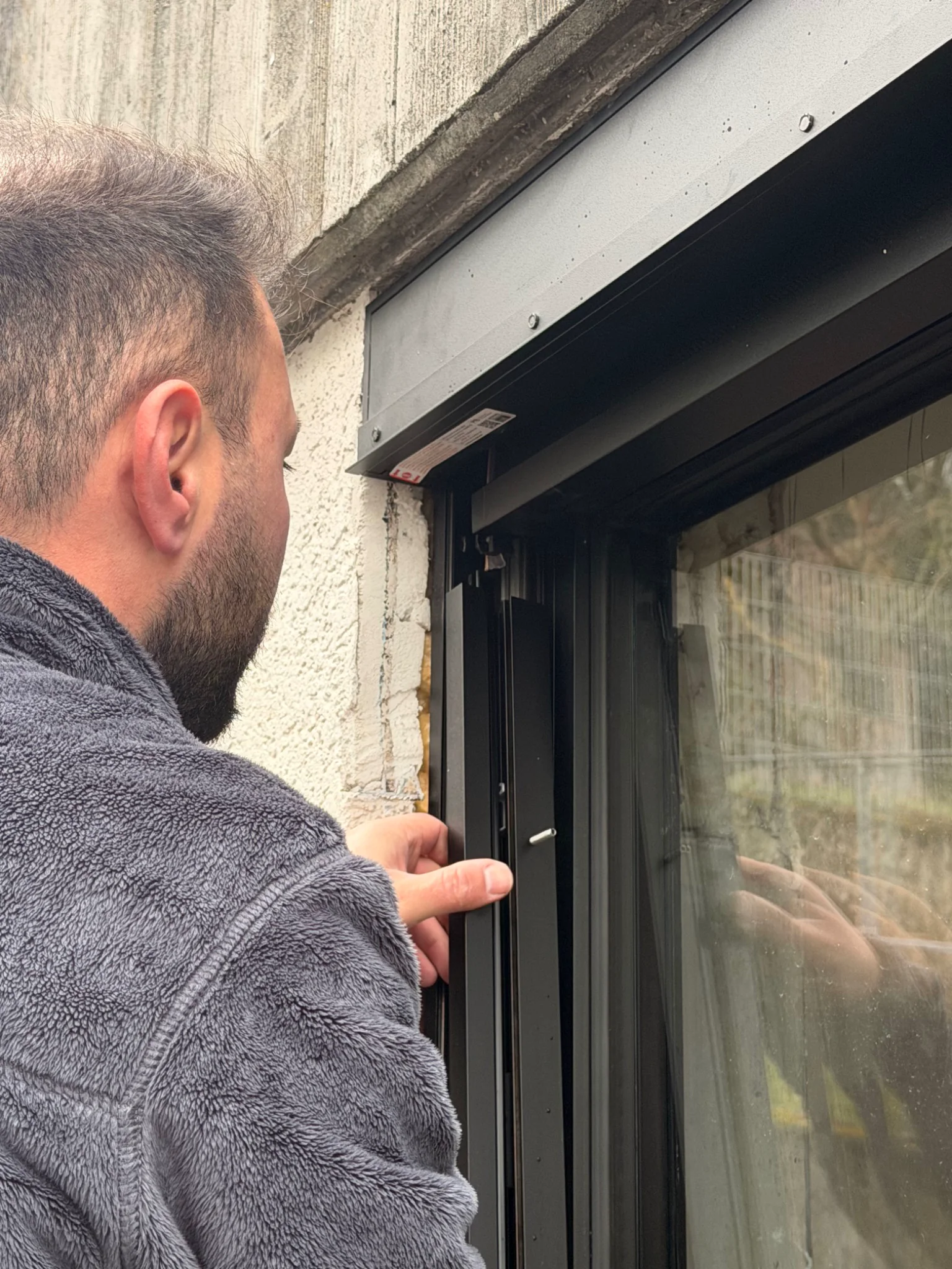 Techniker prüft einen ZIP-Screen am Fenster